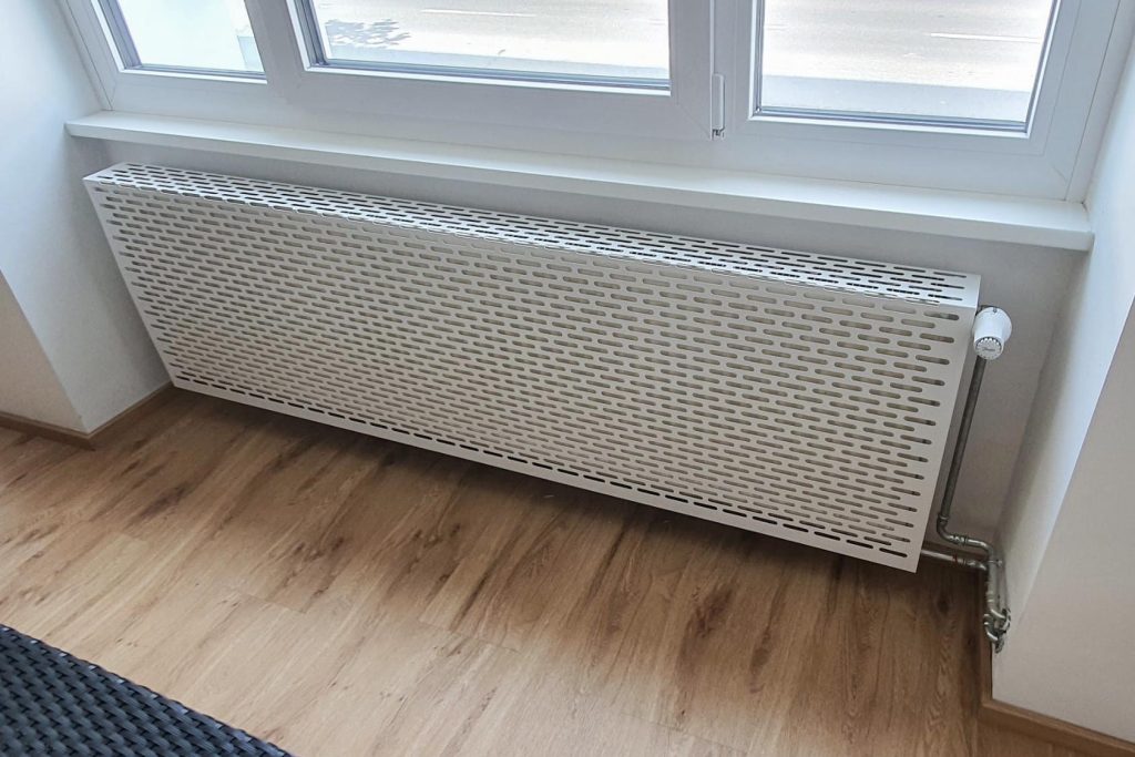Weisse Aluminium-Verblendung von einem Heizkörper in einer Wohnung